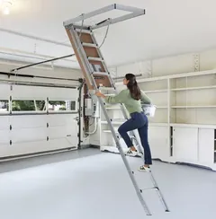 Homeowner pulling down a Louisville Ladder attic ladder for storage access