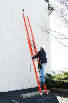 Contractor using a Louisville Ladder extension ladder on a building facade