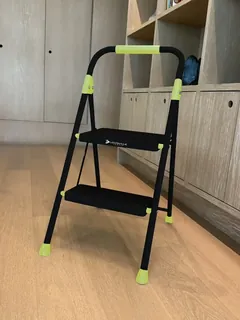 Person using a Louisville Ladder step stool to reach a high shelf