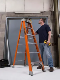 Worker using a Louisville Ladder A-frame step ladder on a job site