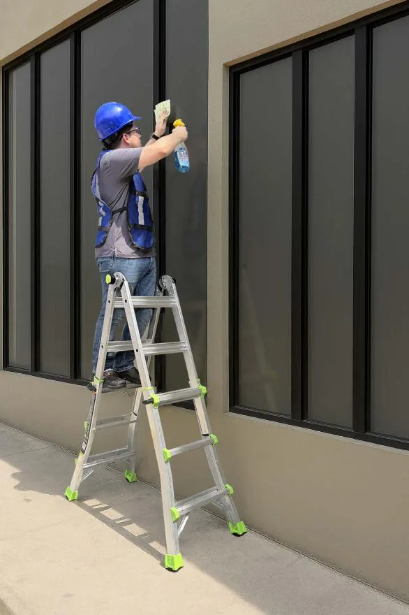 Worker using a Louisville Ladder multipurpose ladder in the stepladder position to clean a window