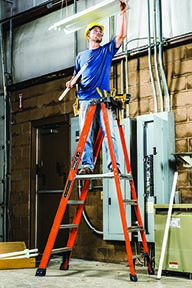 Construction worker replacing overhead fluorescent lights while standing on a platform ladder by Louisville ladder